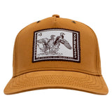 Front of a light brown cap featuring a stamp-like patch containing two ducks in flight and text.