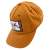 Side of a light brown cap with a white and brown stamp patch on the front.