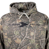 Close up of a brown camouflage hoodie with a black Xpress logo on the chest. 