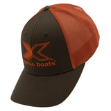 A two-tone trucker hat with a brown front panel and orange mesh back panels. The front panel features a large embroidered orange 'X' logo.